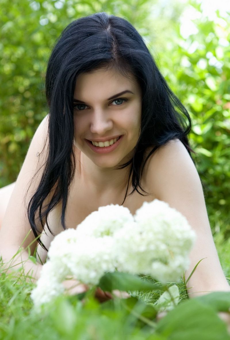 black haired girl with blue eyes taking photos in the nature