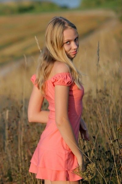 cute young blonde girl outside on a meadow