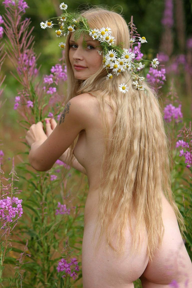 young blonde girl outside making a daisy wreath