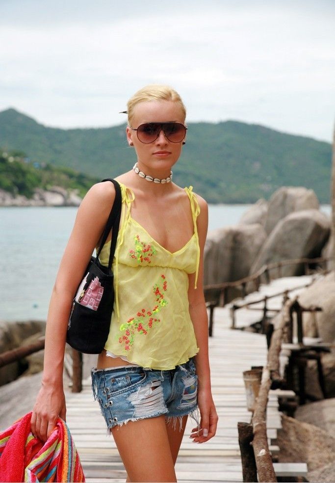 skinny blonde girl wearing short jeans near the sea