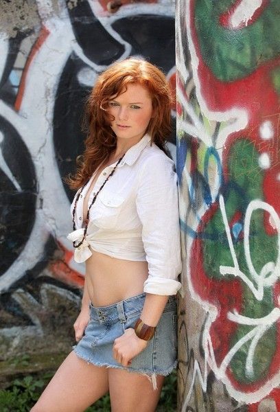 red haired girl undresses outside on the street