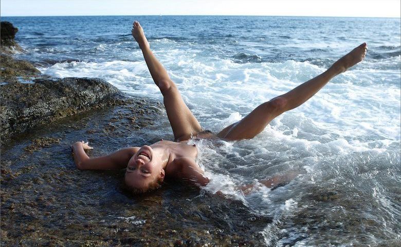 young brunette girl taking photos in the sea