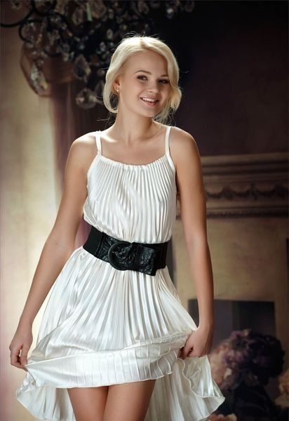 cute young blonde girl undresses her white dress