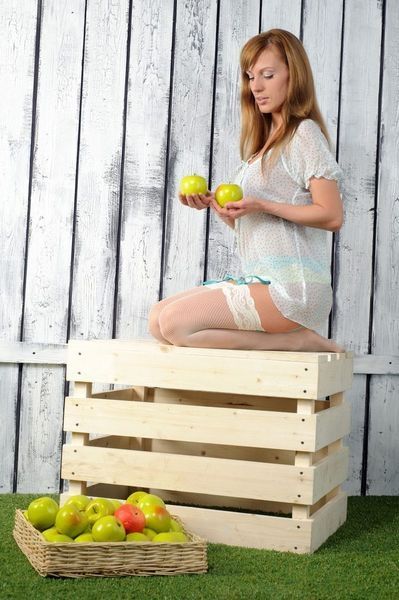 reddish blonde girl posing with apples