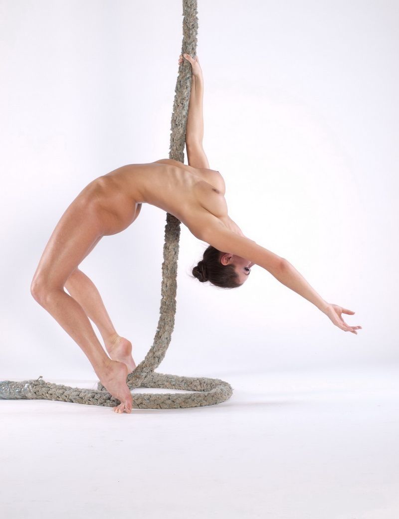 brunette girl doing gymnastic exercises with a rope