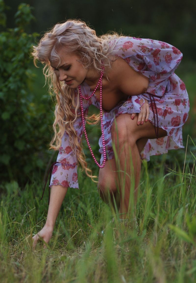 blonde girl reveals her body on the grass glade