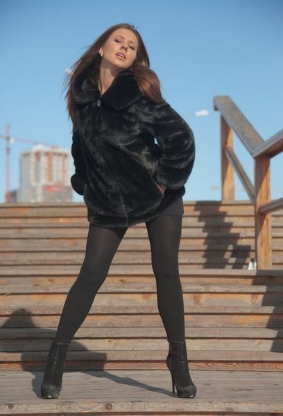 young brunette girl outside in the black coat
