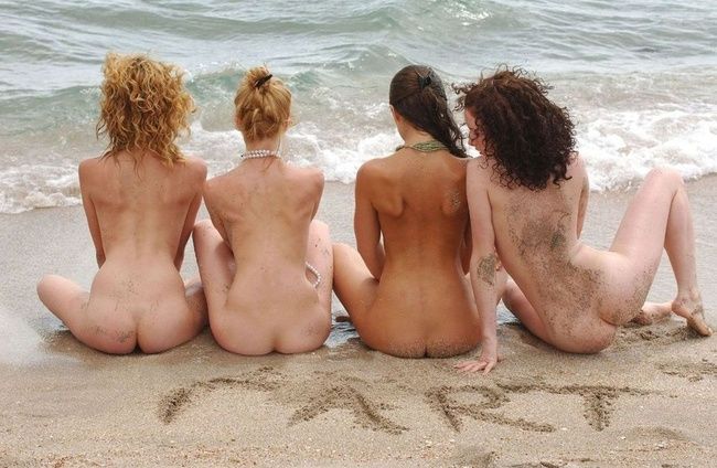 four young girls relaxing on the beach