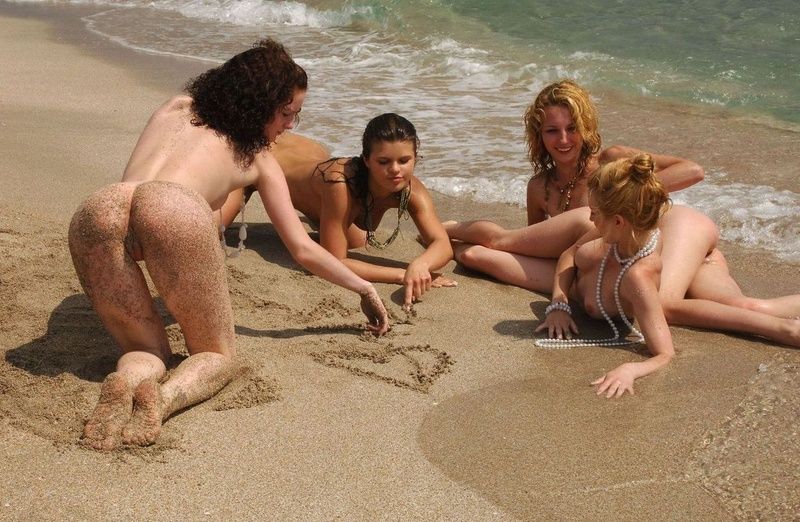 four young girls relaxing on the beach