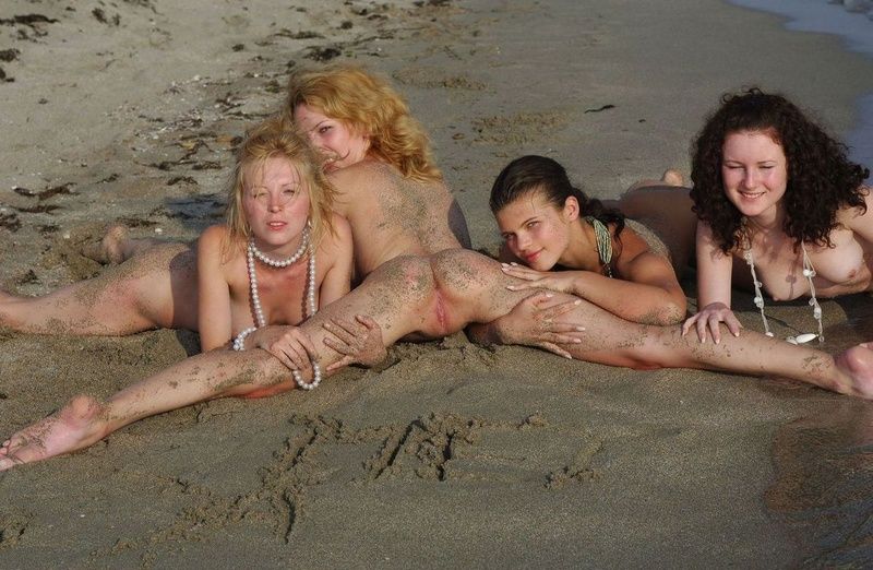 four young girls relaxing on the beach