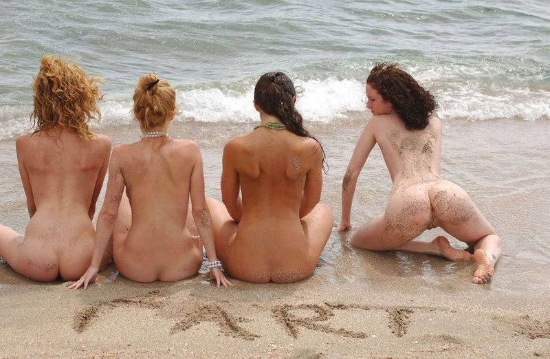 four young girls relaxing on the beach