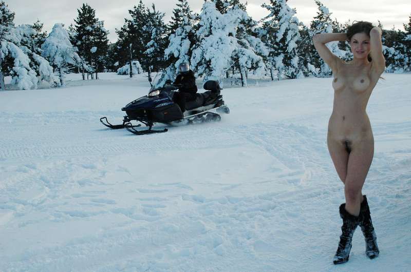 young brunette girl loves the winter and snowmobiles