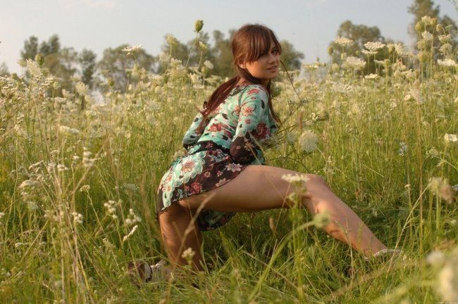 young brunette girl on the field of wild flowers