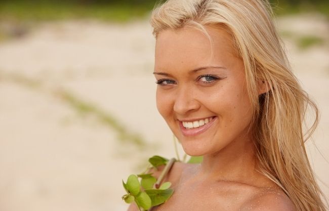 blonde girl on the beach with plants