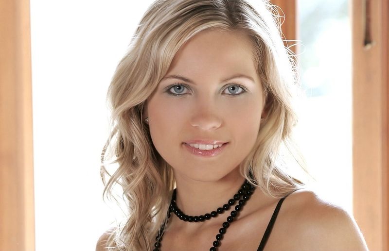 blonde girl with necklace undresses black negligee
