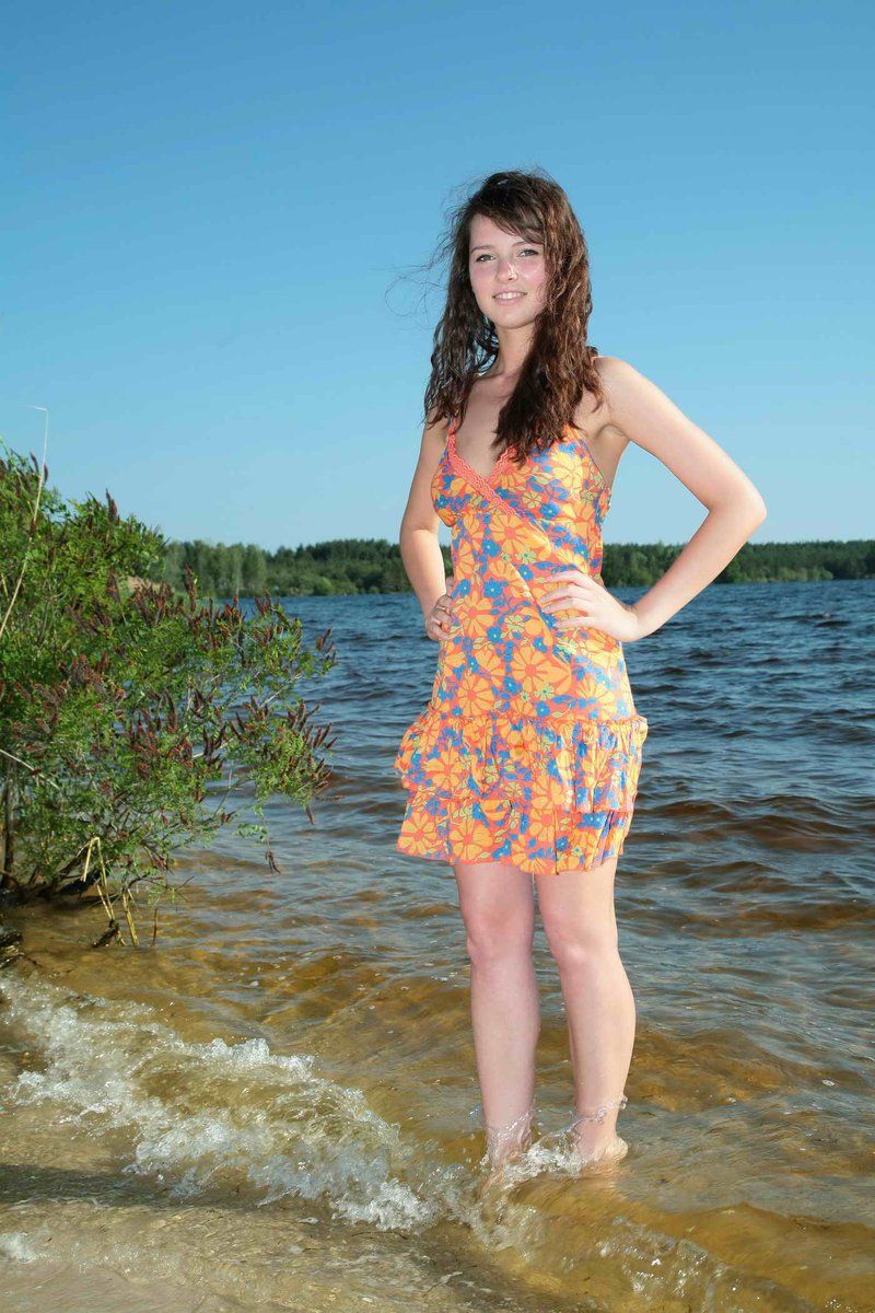 young curly brunette girl reveals at the lake shore