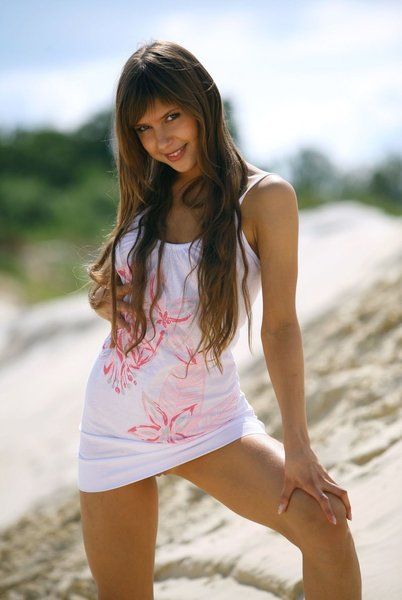 cute young brunette girl posing in the sand