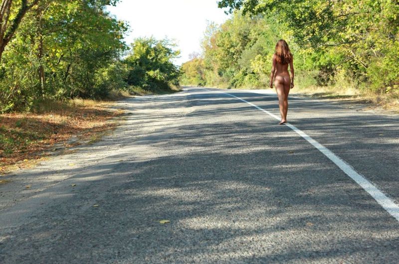 cute young brunette girl reveals on the empty road