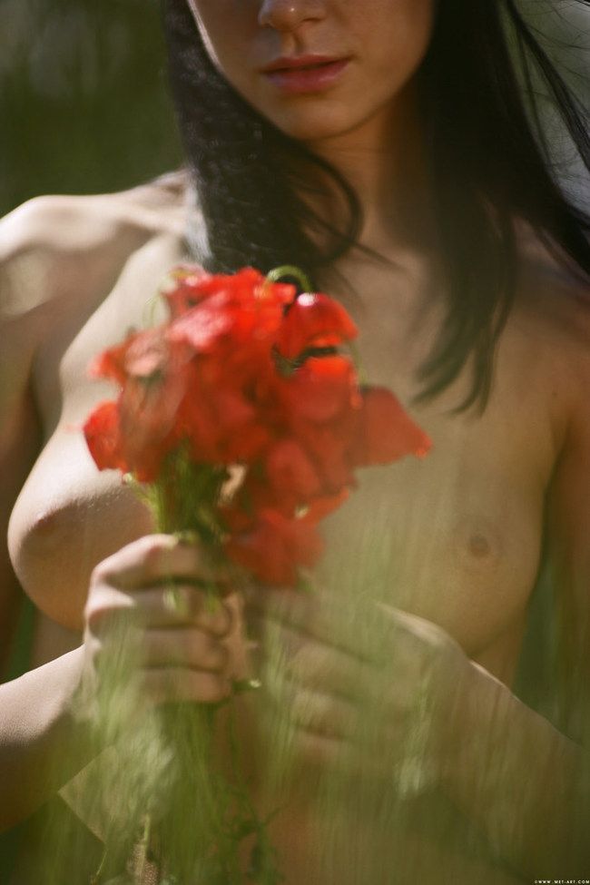 young brunette girl outside on the field with red poppies