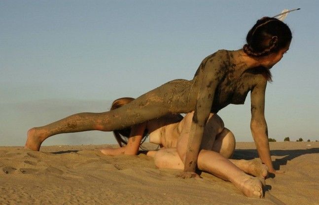 two young dirty girls show off on the sand