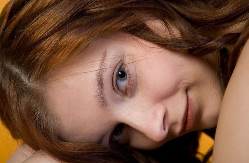 cute young curly red haired girl posing in the studio