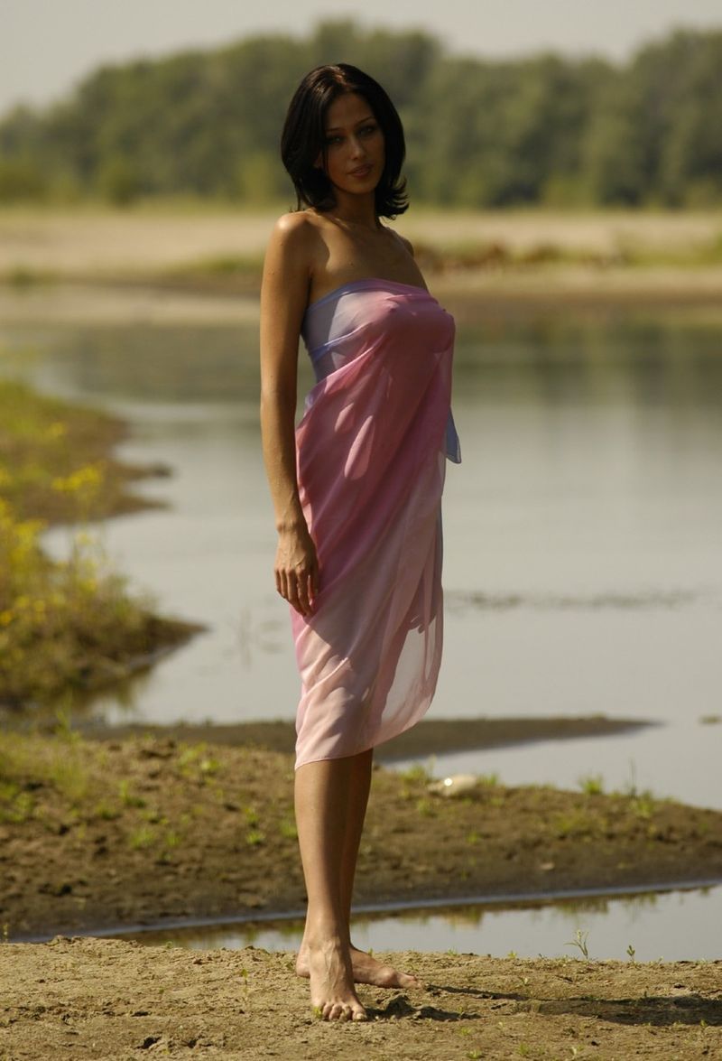 young brunette girl shows off with a pretty scarf at the river