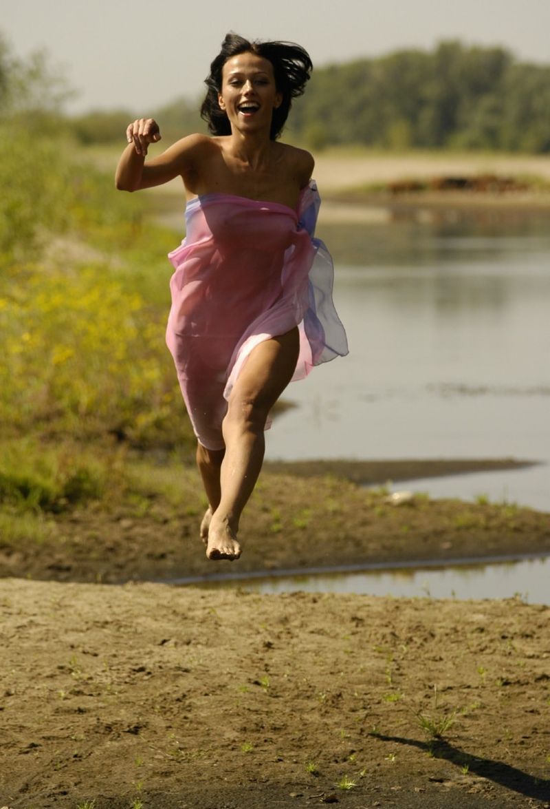 young brunette girl shows off with a pretty scarf at the river