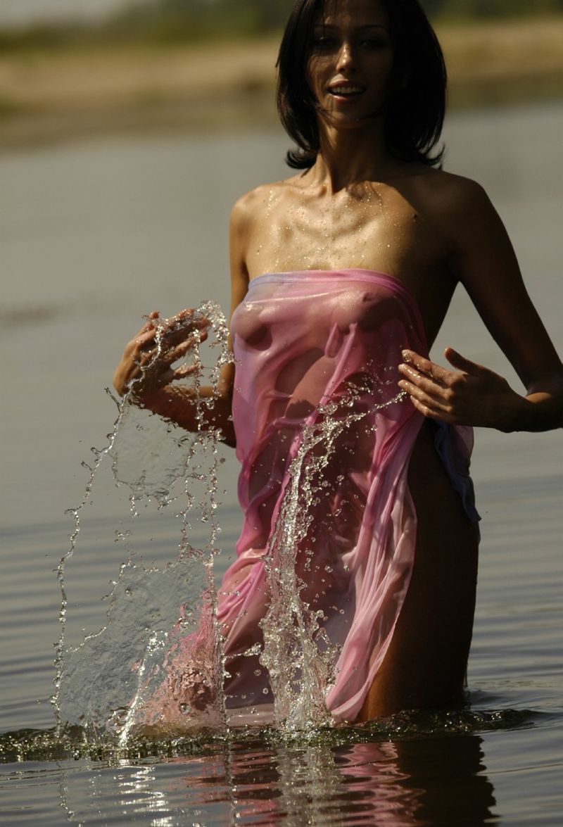 young brunette girl shows off with a pretty scarf at the river