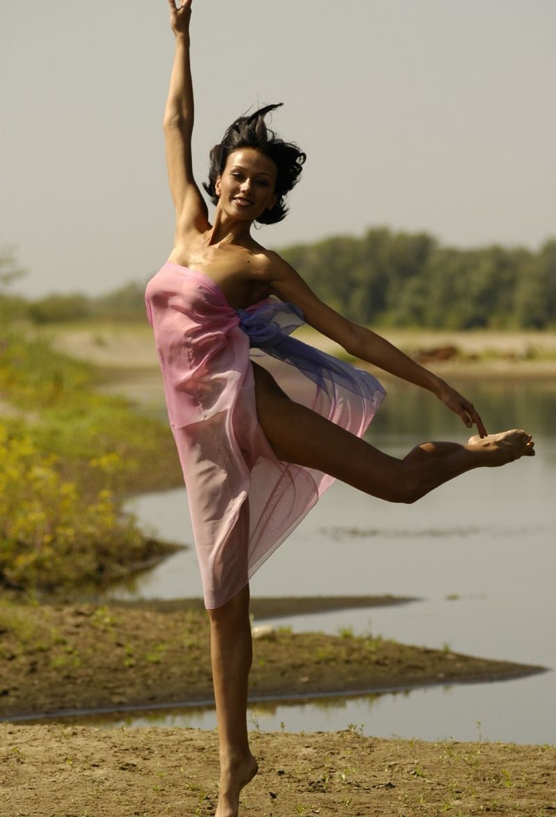 young brunette girl shows off with a pretty scarf at the river