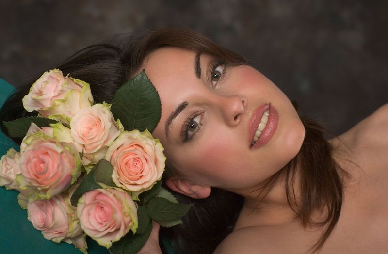 young brunette girl posing with pink roses
