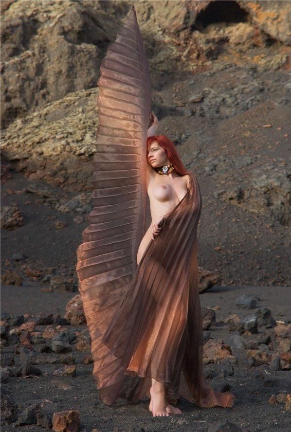 young red haired girl with butterfly wings on rocky mountains