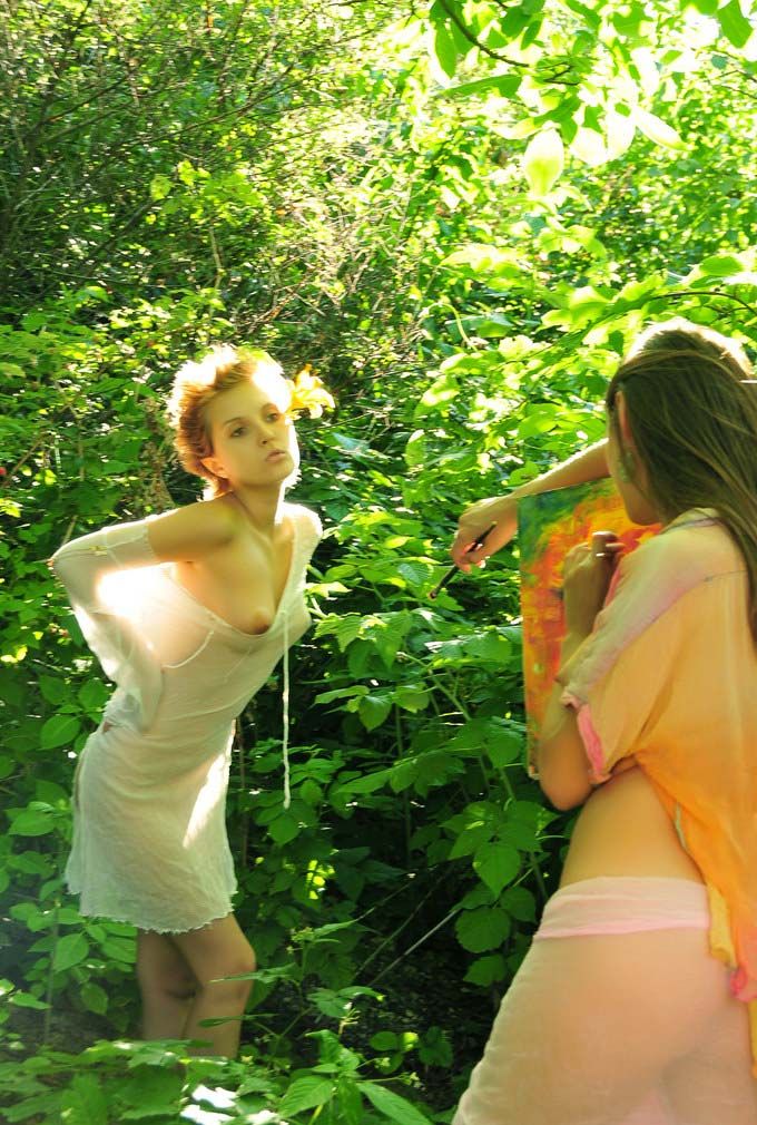 two young girls painting in the deciduous forest