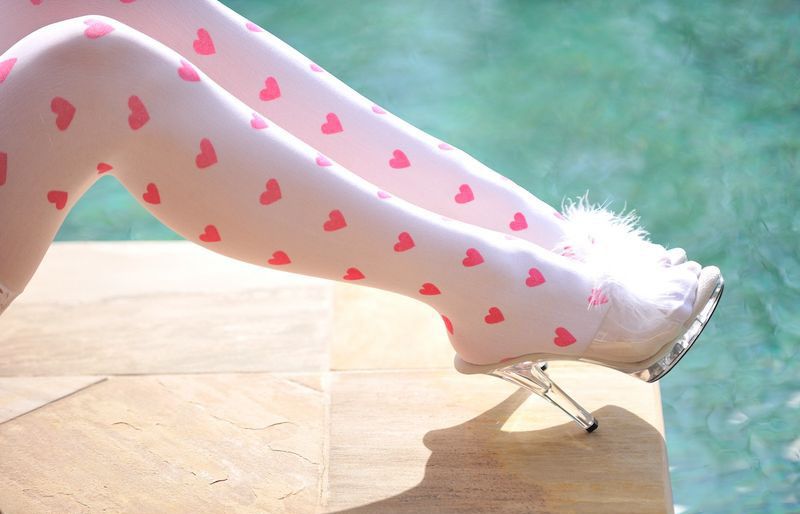 blonde girl wearing a costume with angel wings and stockings with little pink hearts