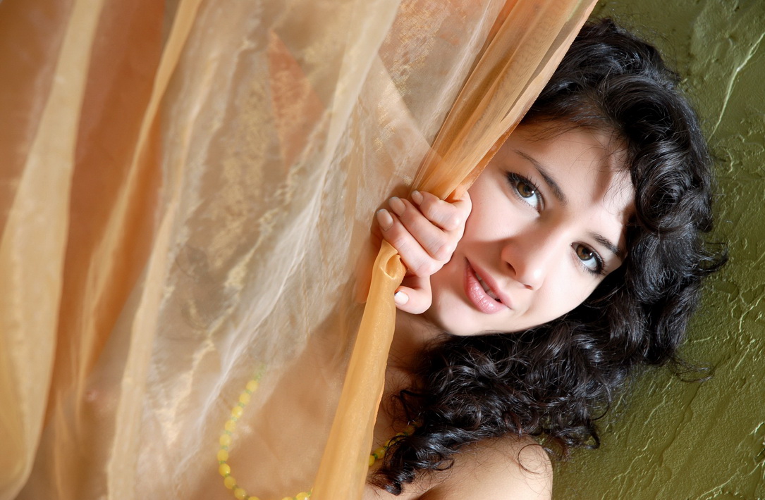 young curly black haired girl wearing striped stockings in the bedroom