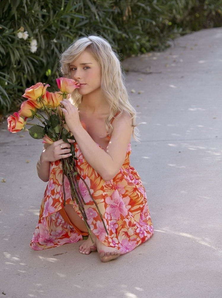 young blonde girl with roses reveals outside on the road