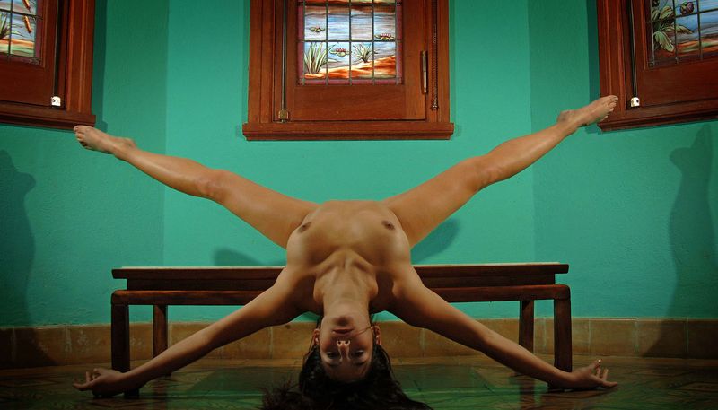 brunette girl doing gymnastic exercises in the church with stained glass windows