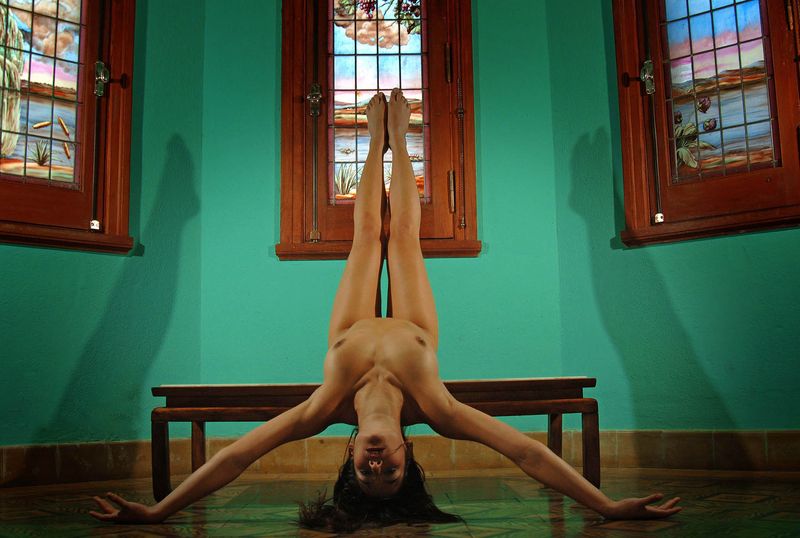 brunette girl doing gymnastic exercises in the church with stained glass windows