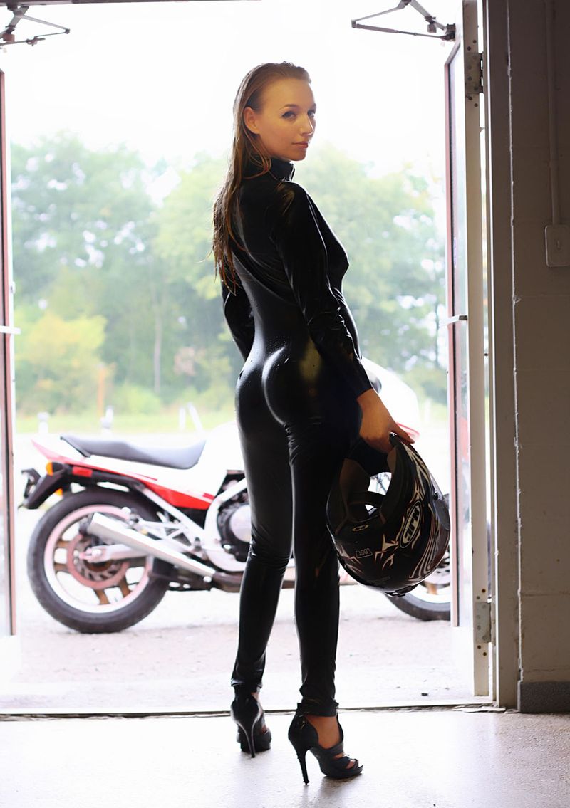 blonde girl undresses her leather overall on the honda motorcycle