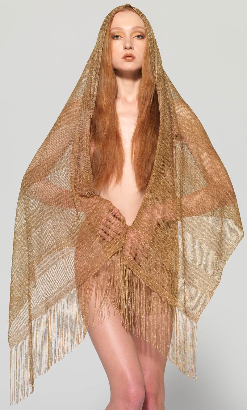 young red haired girl shows off with a golden scarf in the studio