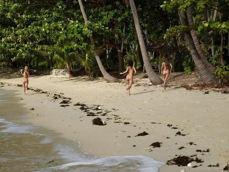 three cute young girls relaxing on caribbean beach at beautiful sunny day