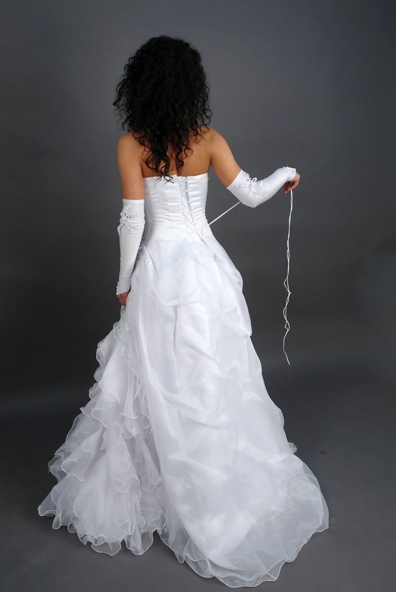 curly black haired girl strips her wedding dress in the studio