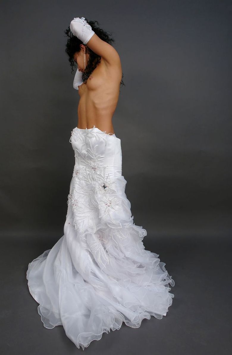 curly black haired girl strips her wedding dress in the studio