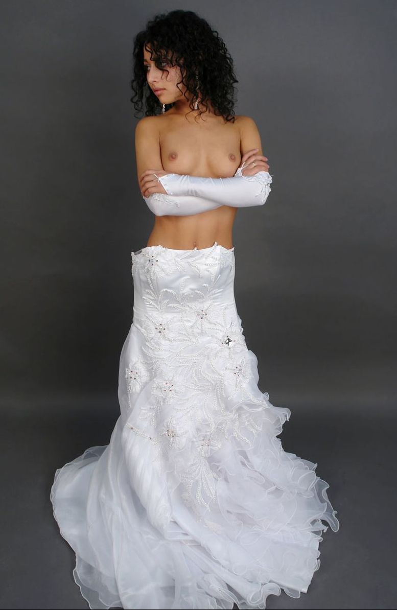 curly black haired girl strips her wedding dress in the studio