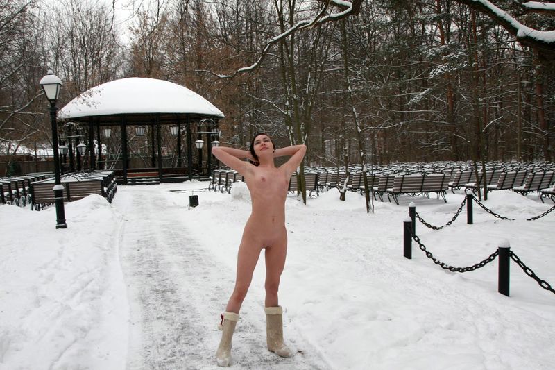 young black haired girl with a headband and boots outside in the amphitheatre in the winter