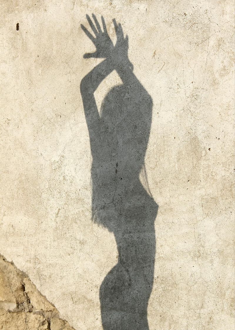 young brunette girl strips her red skirt and white sleeveless shirt near the old building