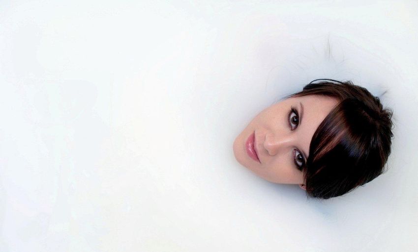 brunette girl with brown eyes posing in the bathtub
