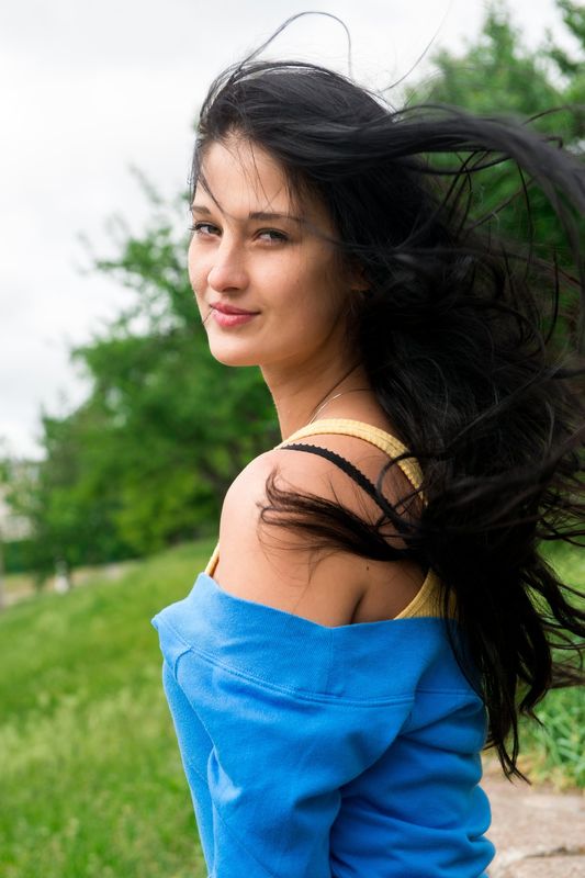 young black haired girl undresses her bodysuit on the field of dandelions