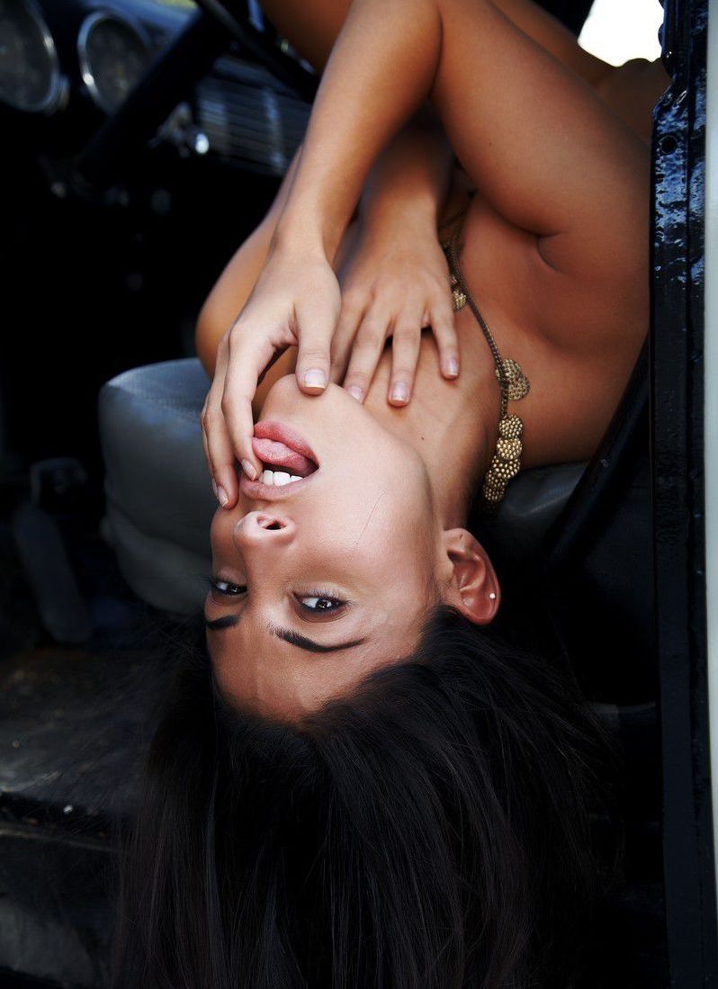 young brunette girl reveals her necklace and brown boots in the car