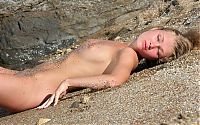 Babes: young golden blonde girl on rocky beach