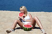 Babes: young blonde girl on the beach eating a watermelon